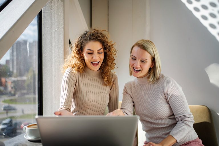 Two marketers catching up on the latest agency news on a laptop