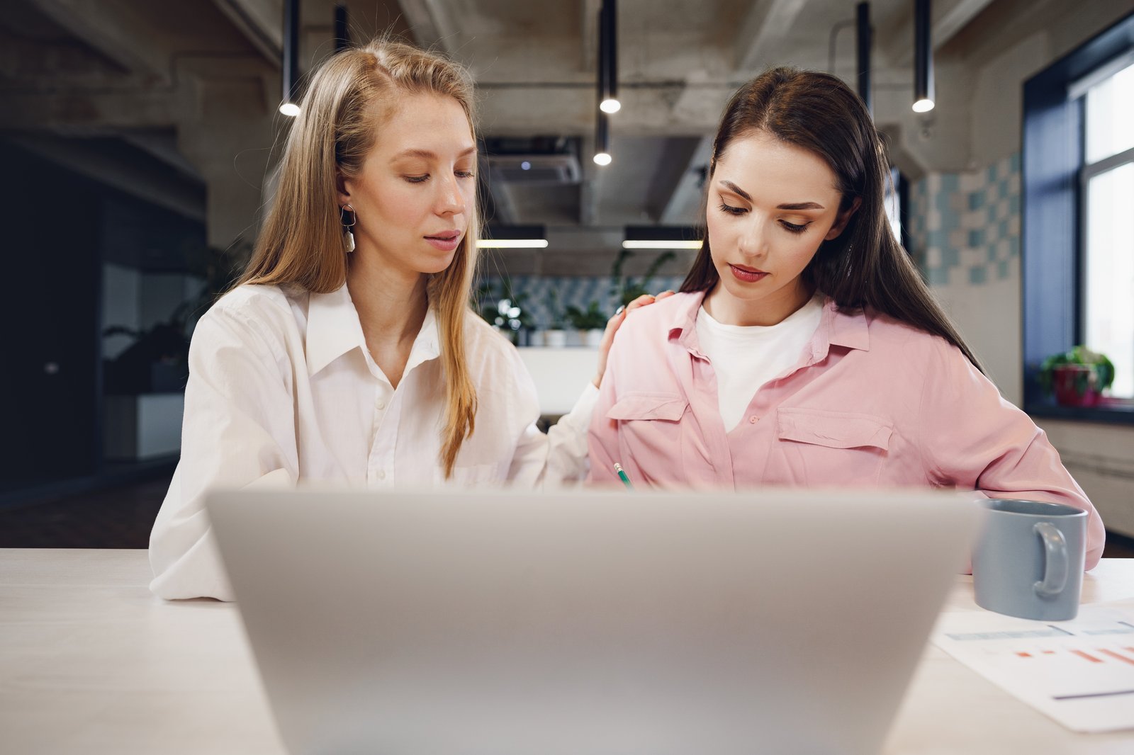 Two women reviewing candidate profiles together on a laptop